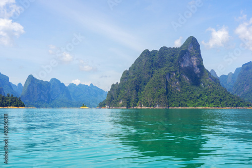 Limestone mountain in lake with mountain range and sky background
