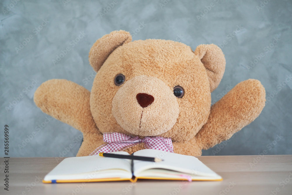 Teddy bear sit on the table and raise his hand Teddy bear sit on the table and raise his hand