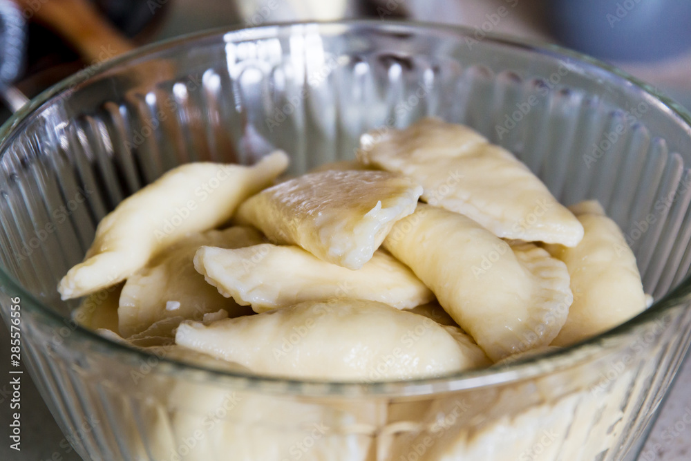 Homemade perogies (varenyky) cooked and placed in a serving bowlt; cooking varenyky from scratch at home in the kitchen Homemade perogies (varenyky) cooked and placed in a serving bowlt; cooking varenyky from scratch at home in the kitchen