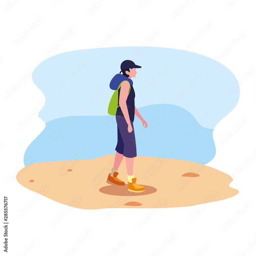 young man with backpack walking sand
