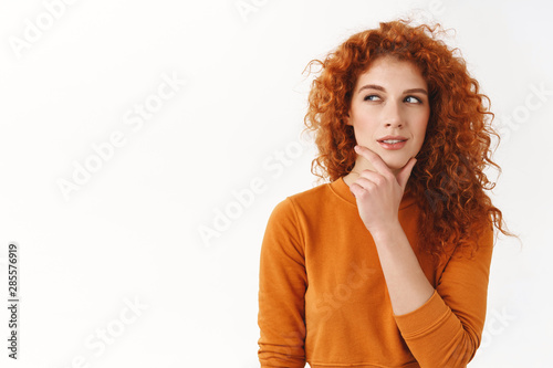 Hmm interesting. Curious cunning good-looking redhead girl planning perfect scheme, rub chin, squinting suspicious and thoughtful peek left, thinking, pondering between nice choices