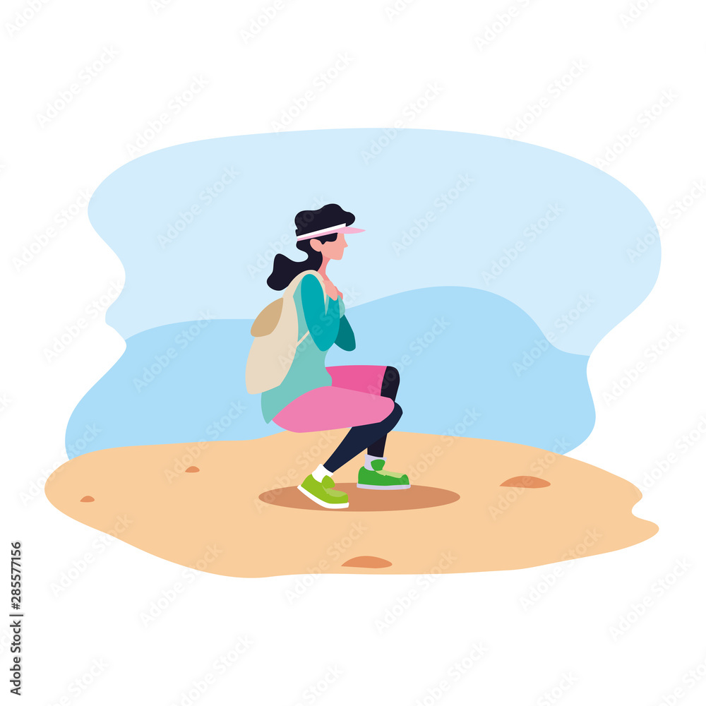 young woman with backpack walking sand