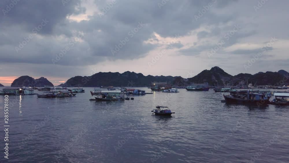Panning of Floating village in Cat Ba Island bay. Traditional boat mooder at Sunset, colorful sky. Panning of Floating village in Cat Ba Island bay. Traditional boat mooder at Sunset, colorful sky.