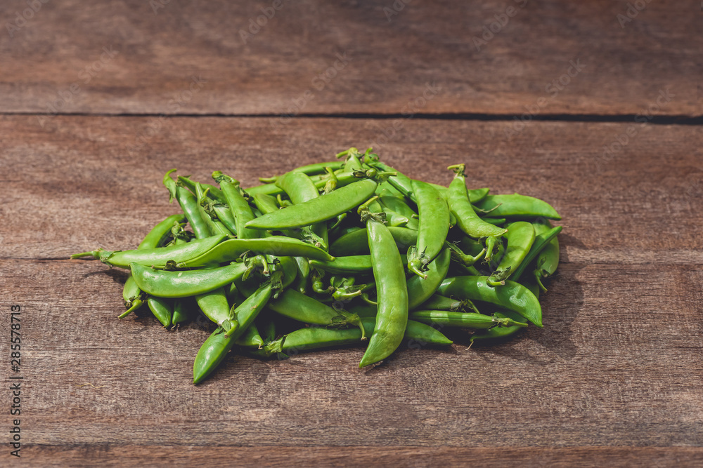 Fresh green peas or beans on wooden table Fresh green peas or beans on wooden table