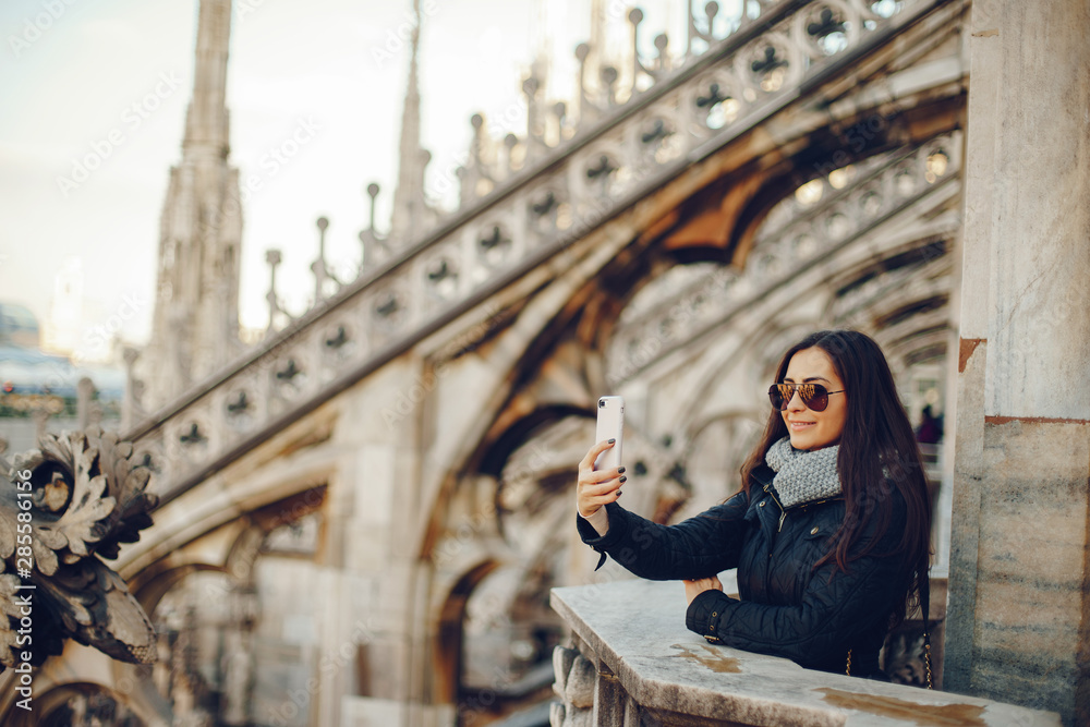 Fototapeta premium girl using her phone while exploring the duomo in Milan Italy