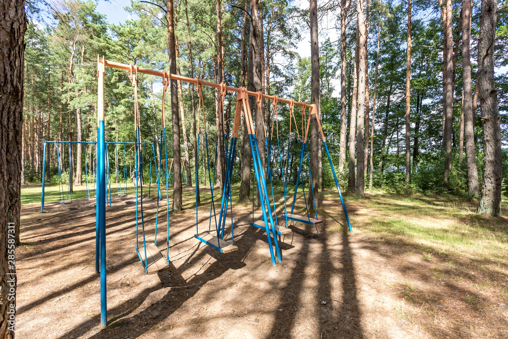 swing and horizontal bars on playground in pine forest swing and horizontal bars on playground in pine forest