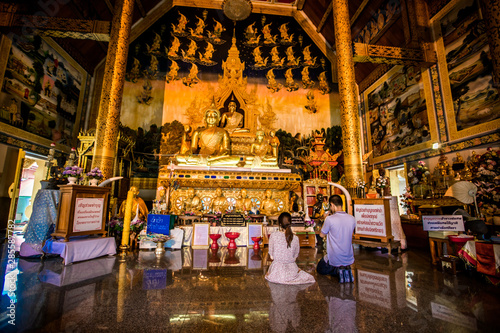 Wat Sri Panthon-Nan: August 10 2019, the atmosphere inside the temple, with sculptures outside the golden-yellow building, tourists traveling to make merit in Nai Wiang area, Mueang Nan, Thailand © bangprik