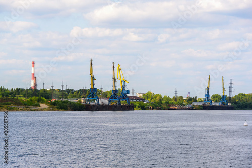 Russia, Moscow August 2018: Unloading of the barge with crushed stone port cranes in the port. © Artemy Sobov