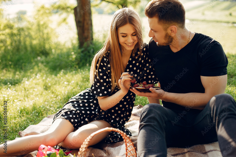 Cute couple in a park. Lady in a black dress. Guy in a black shirt. Cute couple in a park. Lady in a black dress. Guy in a black shirt.