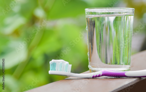 Toothpaste and glass of clean water for brushing teeth. Dental care concept