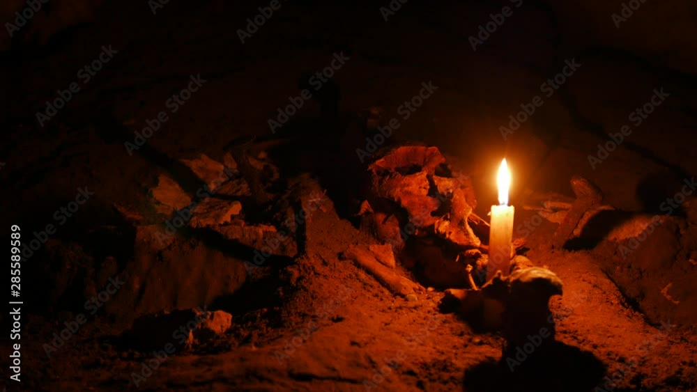Sacrificial altar in an abandoned quarry. A candle burns in the dark against the background of a lamb skull. Most likely this is not serious. Sacrificial altar in an abandoned quarry. A candle burns in the dark against the background of a lamb skull. Most likely this is not serious.