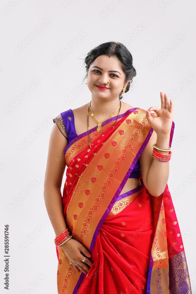 Young Indian woman wearing sari and making OK sign against white background Young Indian woman wearing sari and making OK sign against white background