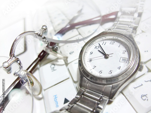 パソコンの上の腕時計とメガネ © chapinasu