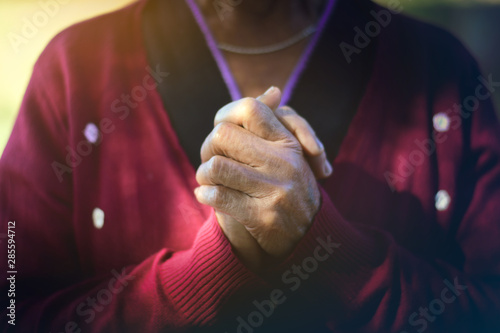 The old woman's closed hand is prayer and thank God.