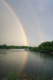 Double rainbow reflected on Ticino river. Cuggiono, Lombardia, Italy. Vertical shot.