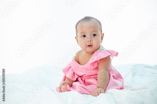 baby sitting on a white bed