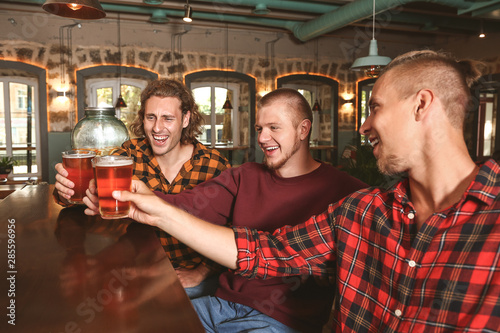 Friends drinking fresh beer in pub