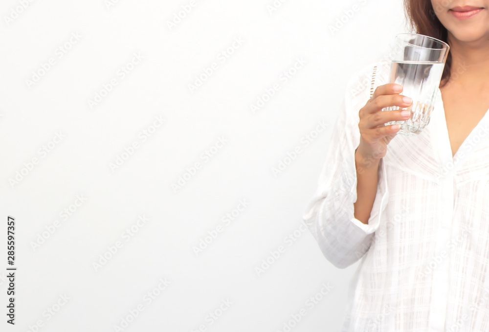 Happy young woman showing drinking glass with water at home. Happy young woman showing drinking glass with water at home.