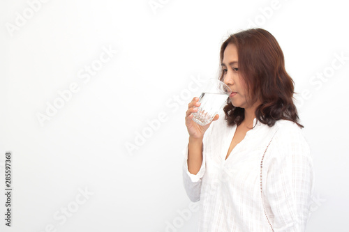 Portrait of a young woman drinking water on white background