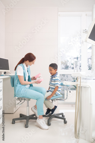 Dark-skinned boy feeling excited while visiting dentist
