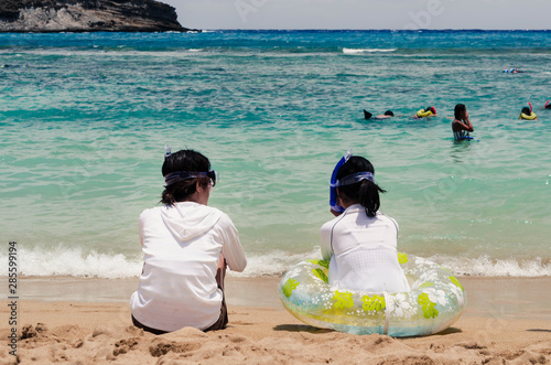 mother and daughter resting on the beach in the hot weather