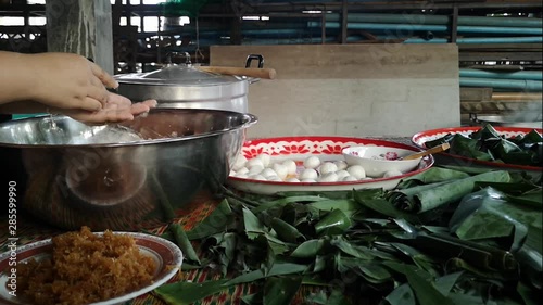 Woman's making rice ball with sweet coconut filling (KaNomTom - Thai's Dessert) photo