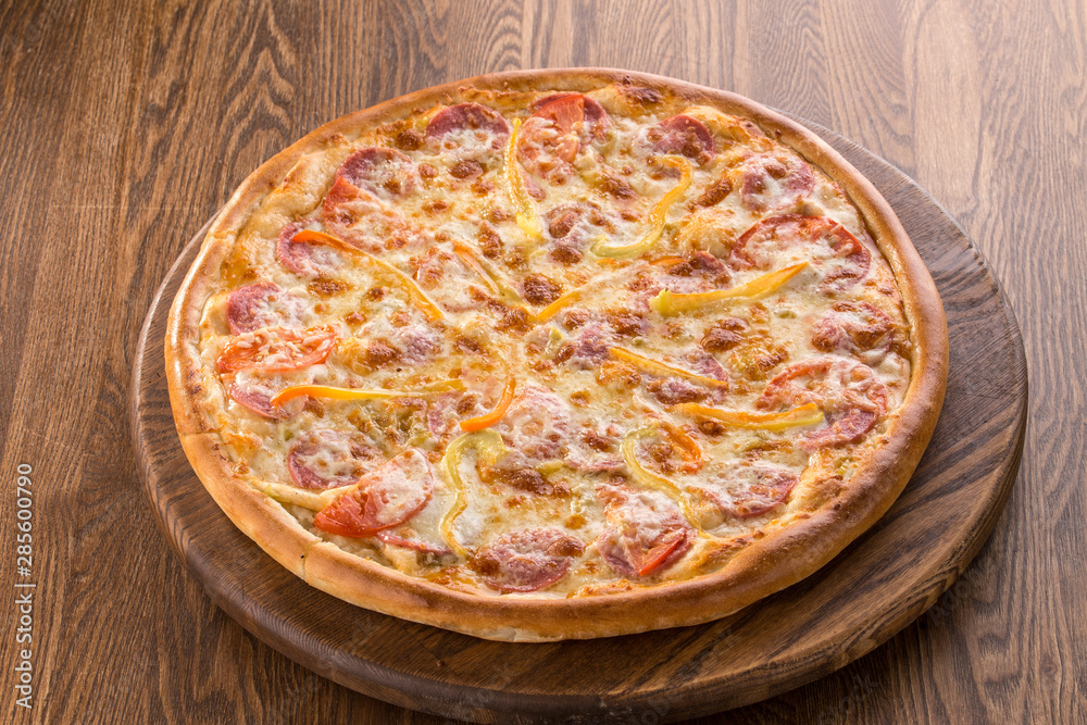 Tasty vegetable pizza with ham isolated on wooden background