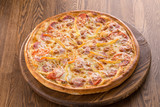 Tasty vegetable pizza with ham isolated on wooden background