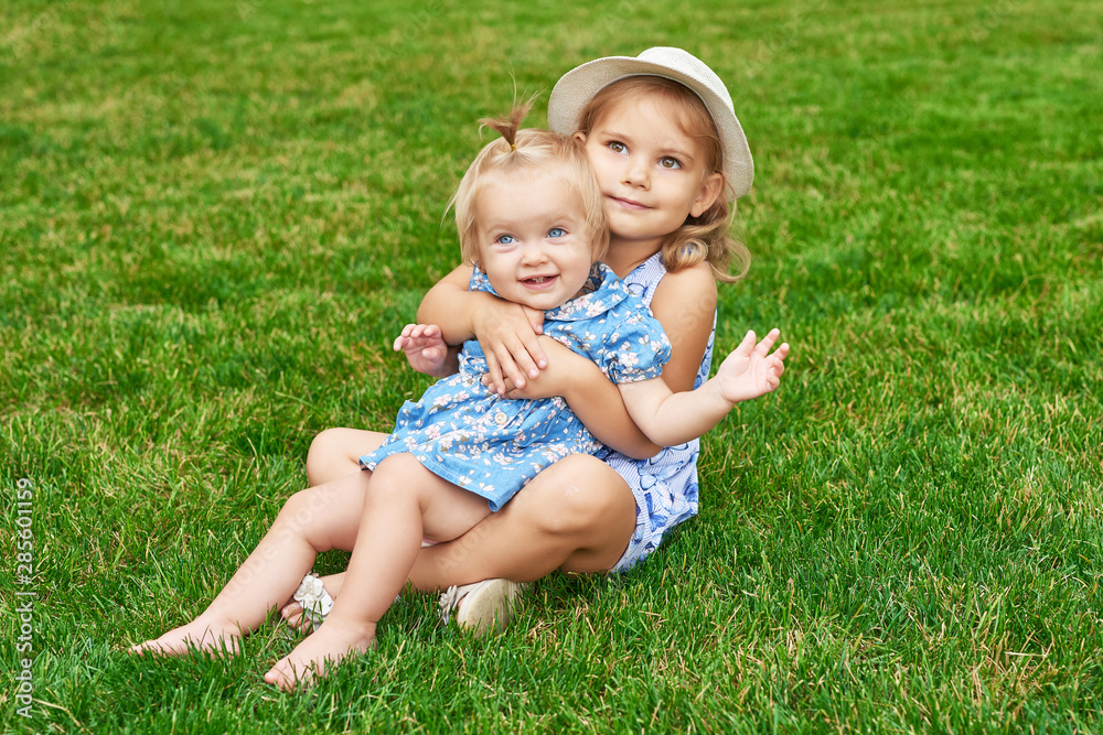 sisters in the park, two girls on a summer picnic sisters in the park, two girls on a summer picnic