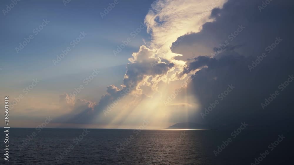 Sun rays break through clouds over ocean in evening time, sunset, steadicam shot Sun rays break through clouds over ocean in evening time, sunset, steadicam shot
