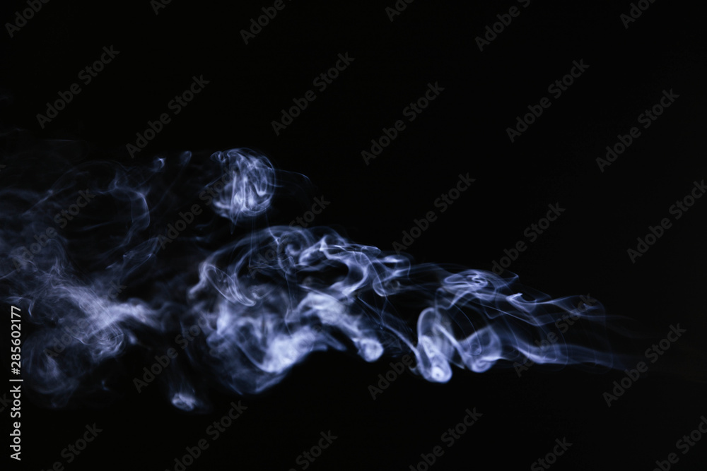 Naklejka premium Blue wavy smoke on black background