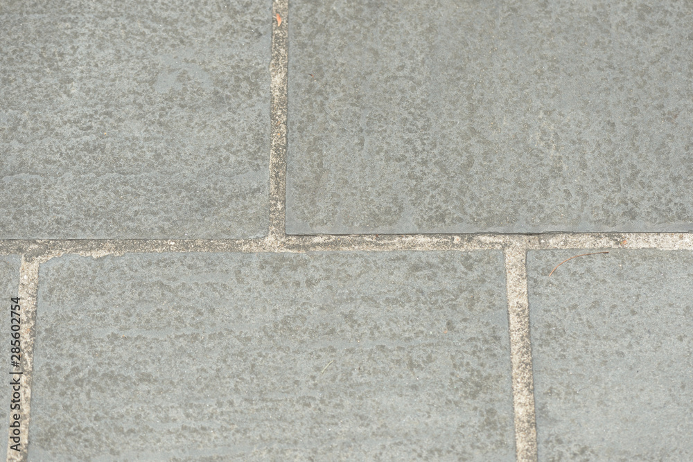 Fototapeta premium Gray paving slabs closeup, top view. Abstract background
