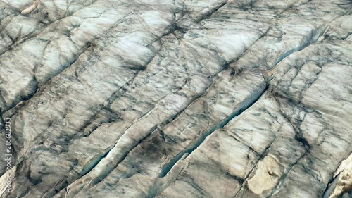 Aerial, top down, drone shot, low, over glacier formations, at Aletsch ice fields, on a partly sunny day, in the Swiss alps of Valais, Switzerland photo