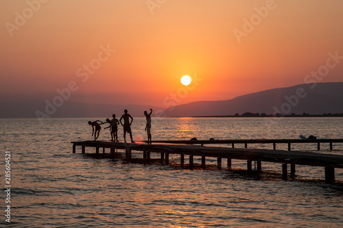 silhouette of vacationers on a pier on Lake Iznik