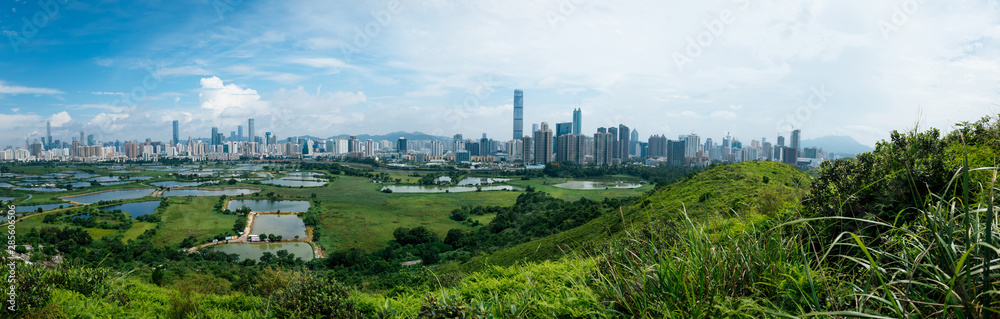 Panorama view of rural green fields with fish ponds between Hong Kong and skylines of Shenzhen,China Panorama view of rural green fields with fish ponds between Hong Kong and skylines of Shenzhen,China