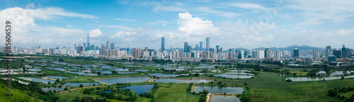 Panorama view of rural green fields with fish ponds between Hong Kong and skylines of Shenzhen,China