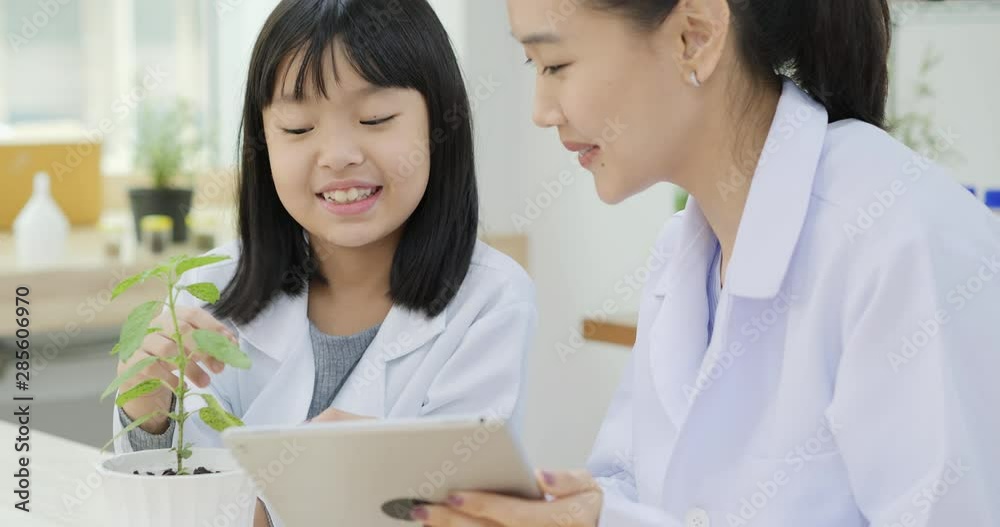 Little Girl and Teacher in Chemistry at Classroom Lab. Educational Biology Project. Science and Education Concept. Little Girl and Teacher in Chemistry at Classroom Lab. Educational Biology Project. Science and Education Concept.