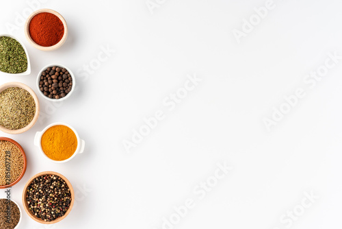Overhead shot of spices in bowls isolated on white background with copyspace