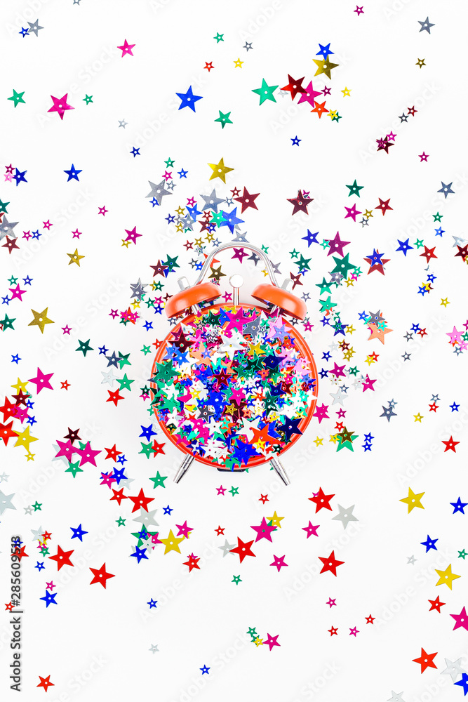 Obraz premium Festive star confetti with red alarm clock concept