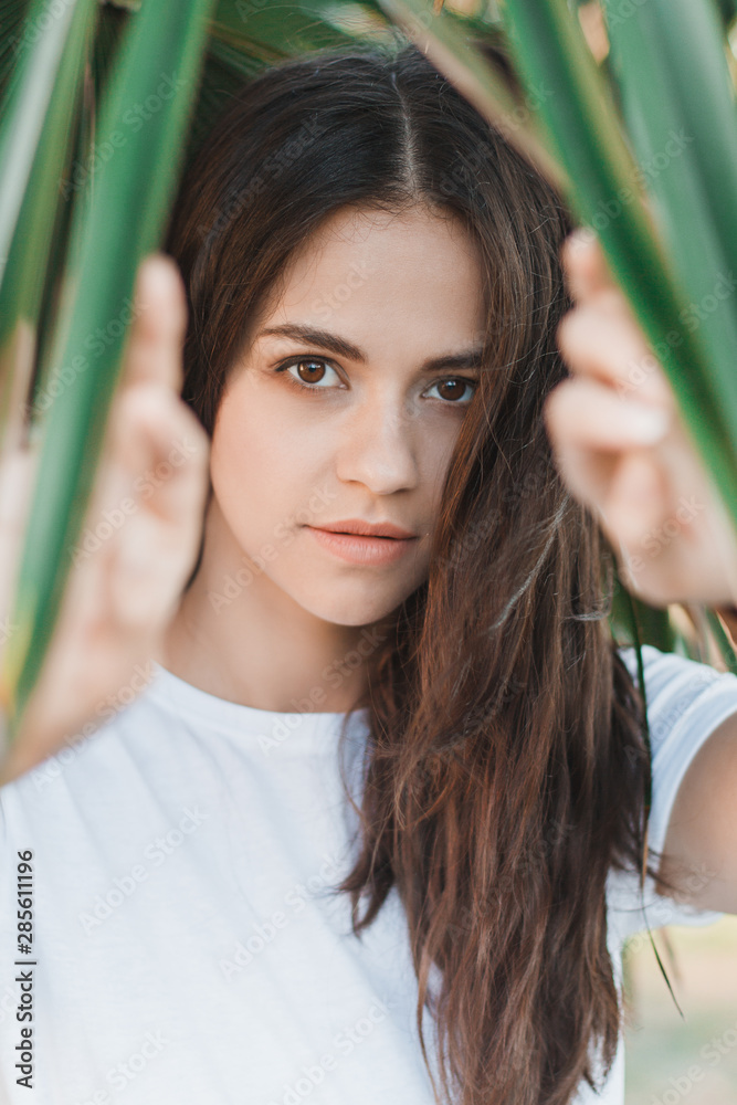 Beautiful young woman portrait. Portrait on Palm Leaves Background. Beautiful young woman portrait. Portrait on Palm Leaves Background.