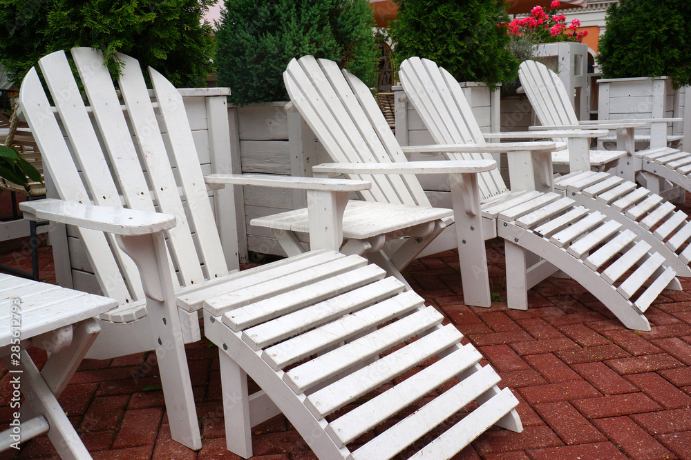 empty wooden chairs on the street. white outdoor furniture empty wooden chairs on the street. white outdoor furniture