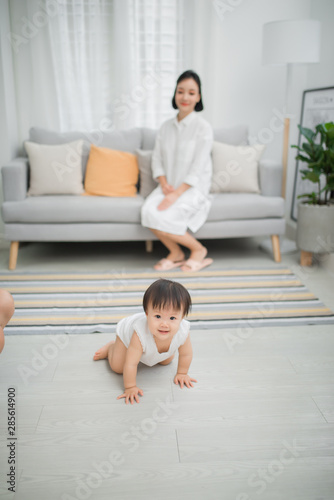 Little girl crawling on the floor in living room