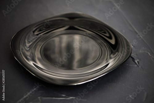 black reflective plate for food on a black background