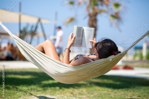 woman reading a book in hammock