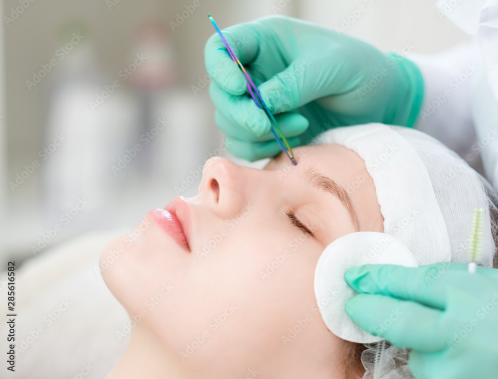 Naklejka premium Beautician performing henna brows correction