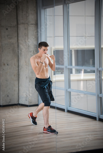 An athletic man boxer standing in fighting protection pose in the studio © KONSTANTIN SHISHKIN