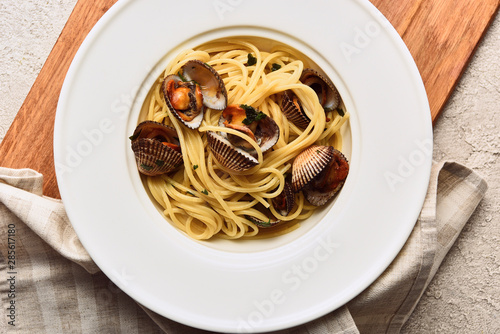 top view of delicious pasta with mollusks on napkin and wooden board