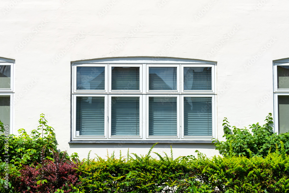 Beautiful wooden window with blinds on a white wall. Architecture. Beautiful wooden window with blinds on a white wall. Architecture.