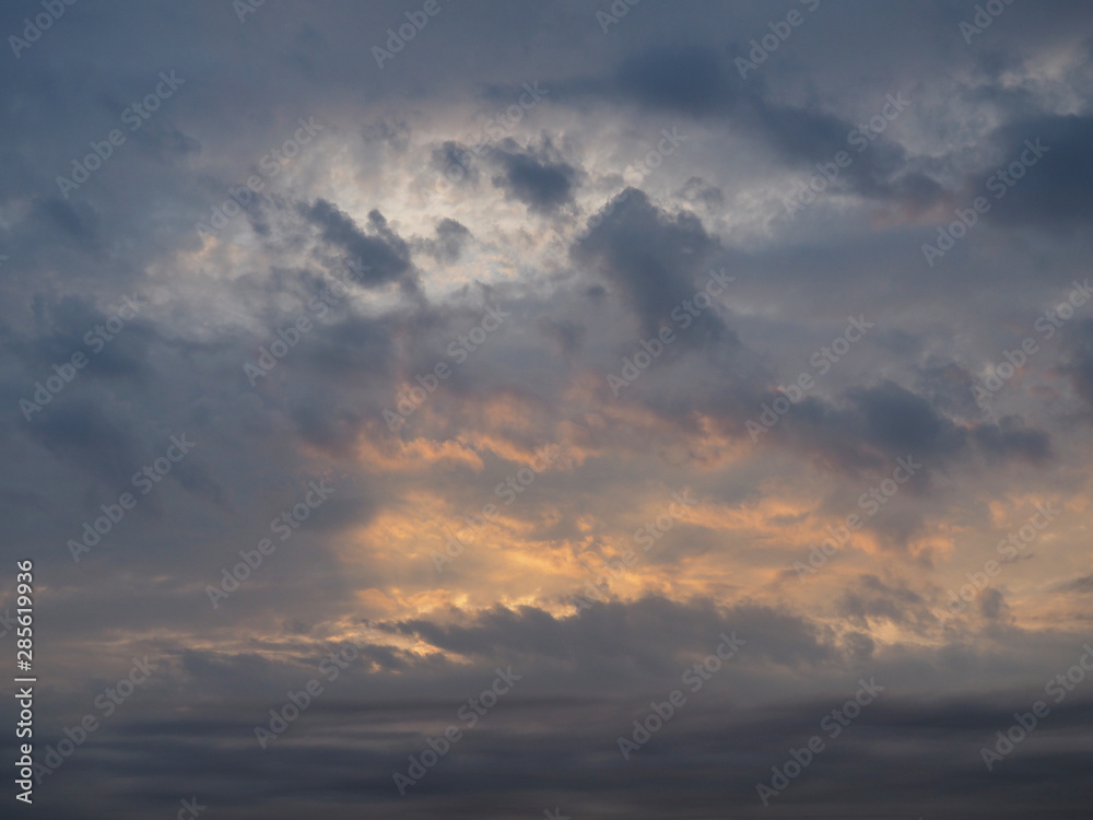 Beautiful multi-colored sky with clouds and light rays of the sun in the evening at sunset. Calm sky background for decoration.