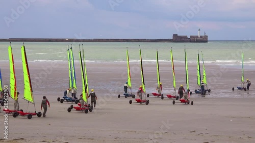 Land carts or sail carts or blokarts are wheeled onto the beach in France.